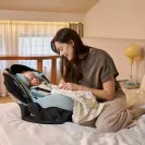 Śpiące dziecko w foteliku samochodowym Avionaut Pixel Pro 2.0 C obok mamy